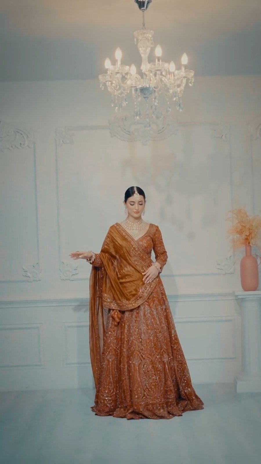 Rust-coloured floor-length lehenga with a dupatta worn over one shoulder
